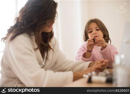 Little girl playing with her mother jewellery and make up