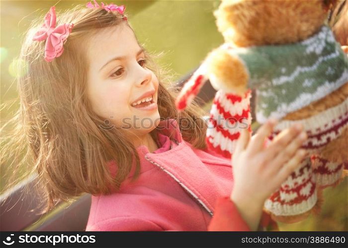 Little Girl Playing with her Teddy Bear in the Bright Spring Day&#xA;
