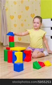 Little girl playing with plasic cubes