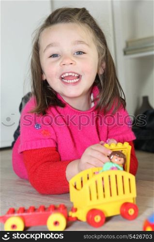 Little girl playing with toys on the floor