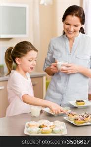 Little girl pointing cupcake to her mother happy at home