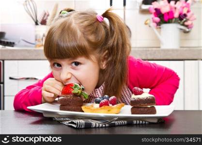 little girl preparing and eating cake with fruit