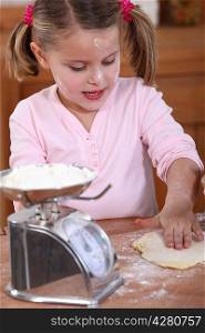 little girl preparing cake with mom