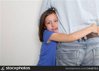 Little girl putting arms around her father&acute;s waist