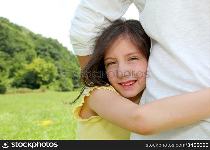 Little girl putting her arms around her father&acute;s waist