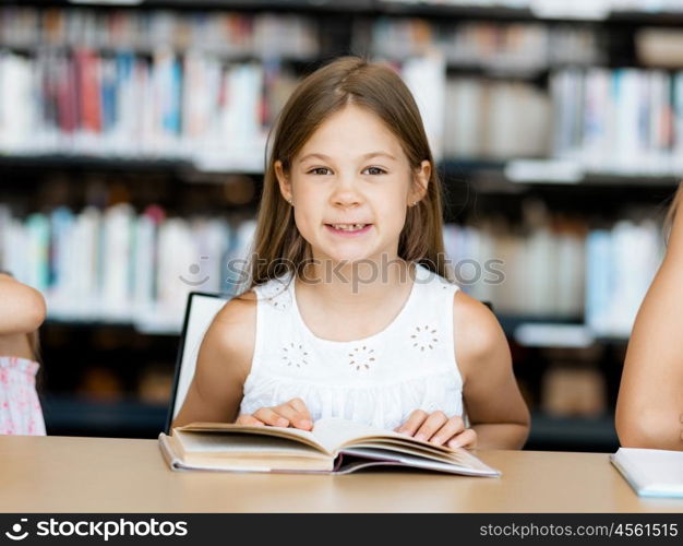 Little girl reading books in library. I love reading