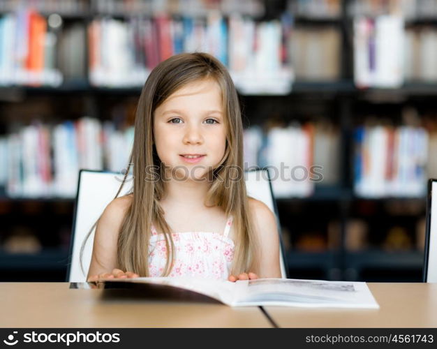 Little girl reading books in library. I love reading