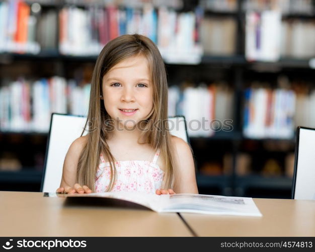 Little girl reading books in library. I love reading