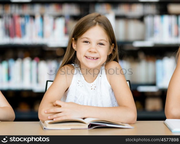 Little girl reading books in library. I love reading