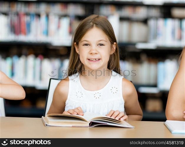 Little girl reading books in library. I love reading