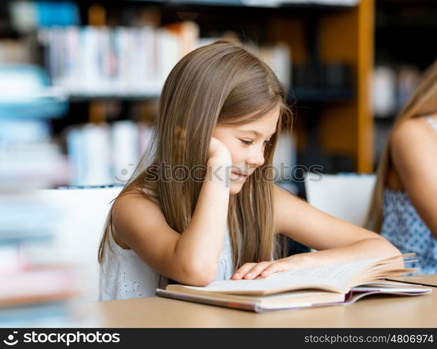 Little girl reading books in library. I love reading