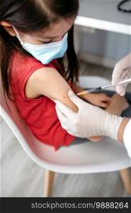 Little girl receiving coronavirus vaccine at doctor’s office