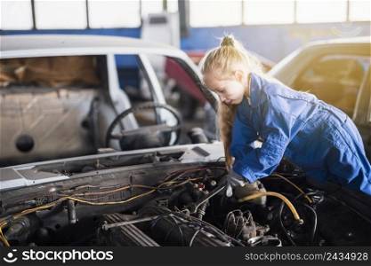 little girl repairing car with spanner
