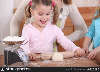 Little girl rolling out pastry