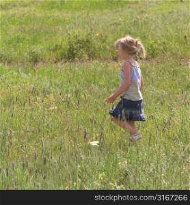 Little girl running through field