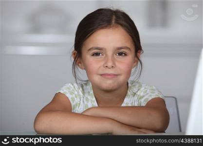 Little girl sat at table