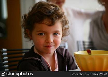 Little girl sat at the breakfast table