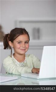 Little girl sat with laptop