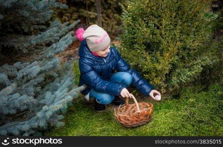 Little girl searching for eggs on Easter at yard
