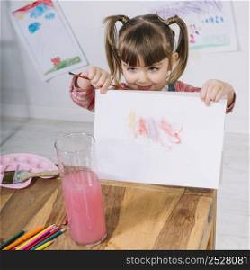 little girl showing painting paper