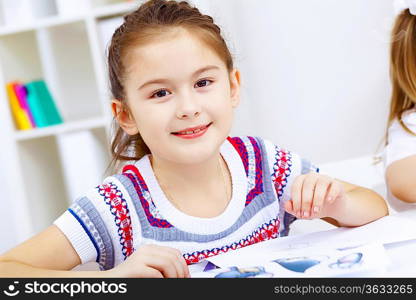 Little girl sitting and studying at home