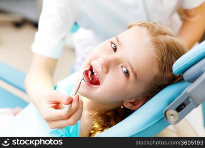 Little girl sitting in the dentists office