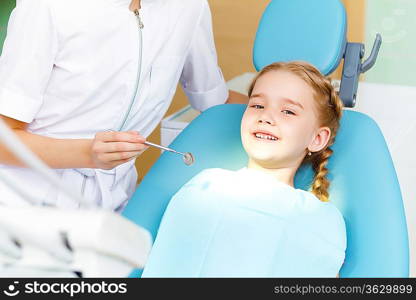 Little girl sitting in the dentists office