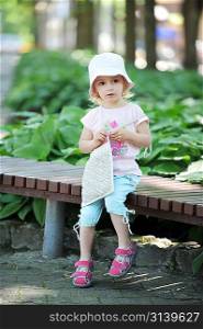 little girl sitting on park bench