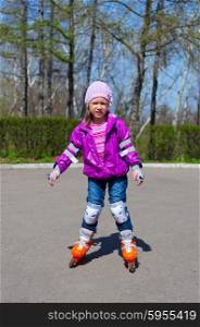 Little girl skating on roller skates at park