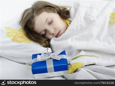 little girl sleeping in her bed with gift