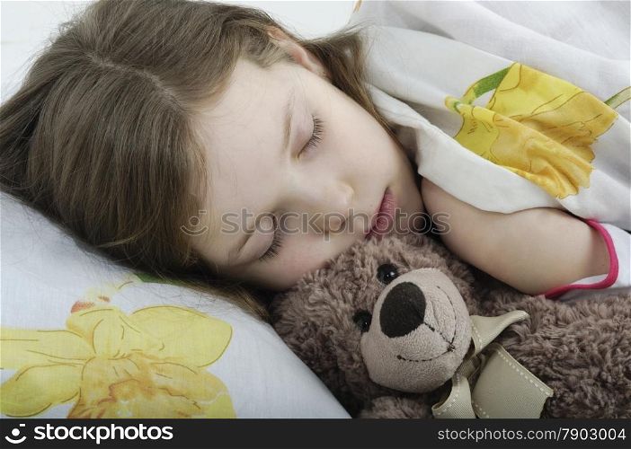 Little girl sleeping in her bed with teddy bear