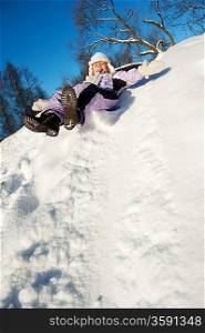 Little girl sliding in the snow