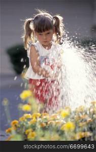 Little Girl Spraying a Garden Hose