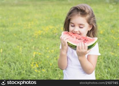 little girl standing field eating red slice watermelon