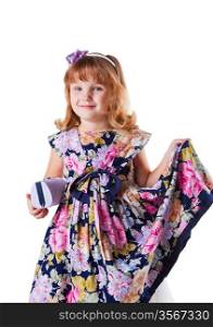 little girl stands with clutch, smiles and holing in hand her dress with flowers on white background