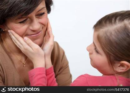 little girl stroking mother&rsquo;s face