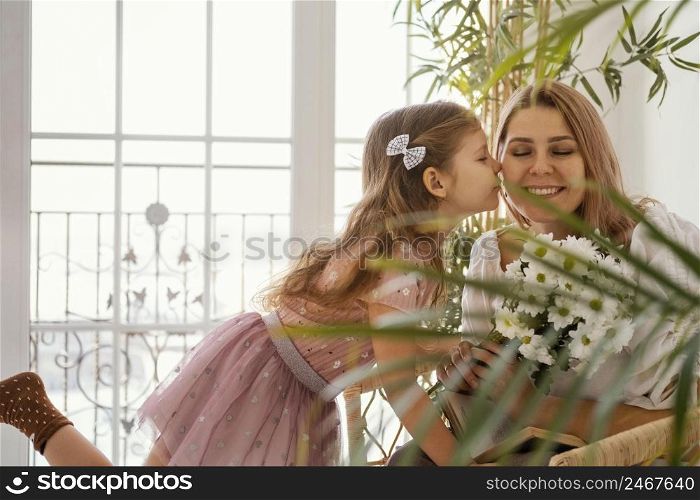 little girl surprising her mother with bouquet spring flowers