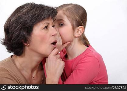 little girl telling her mother a secret