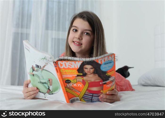 little girl turning over the pages of magazines