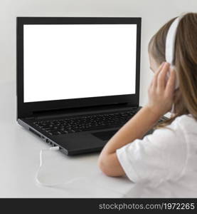 little girl using laptop with headphones. High resolution photo. little girl using laptop with headphones. High quality photo