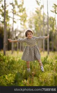 Little girl walking in nature field wearing beautiful dress. Little girl in nature field wearing beautiful dress
