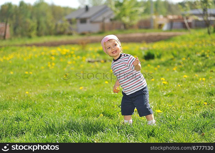 little girl walks across grass