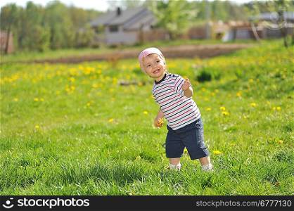 little girl walks across grass