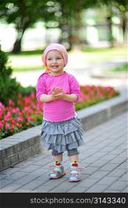 little girl walks in park and flowers