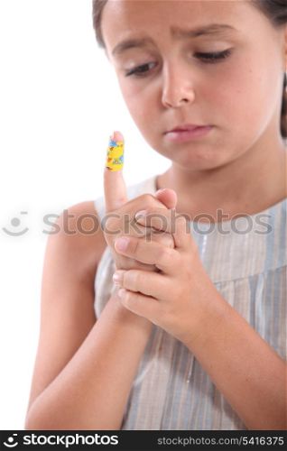 little girl watching a bandage on her finger