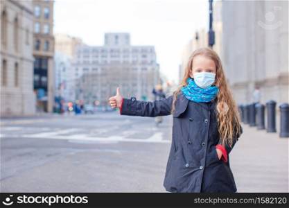 Little girl wearing a mask for prevent virus in empty New York. Young woman walks in empty New York in a mask protecting from the virus
