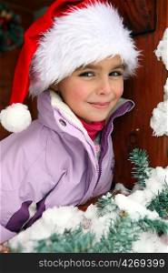Little girl wearing a Santa hat in a chalet