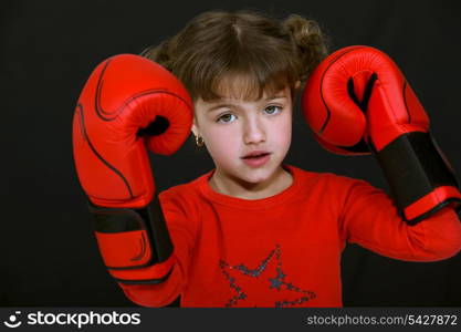 Little girl wearing boxing gloves