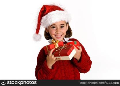 Little girl wearing santa hat carrying many gift boxes for Christmas on white background