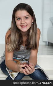 Little girl with a magazine sitting on the stairs